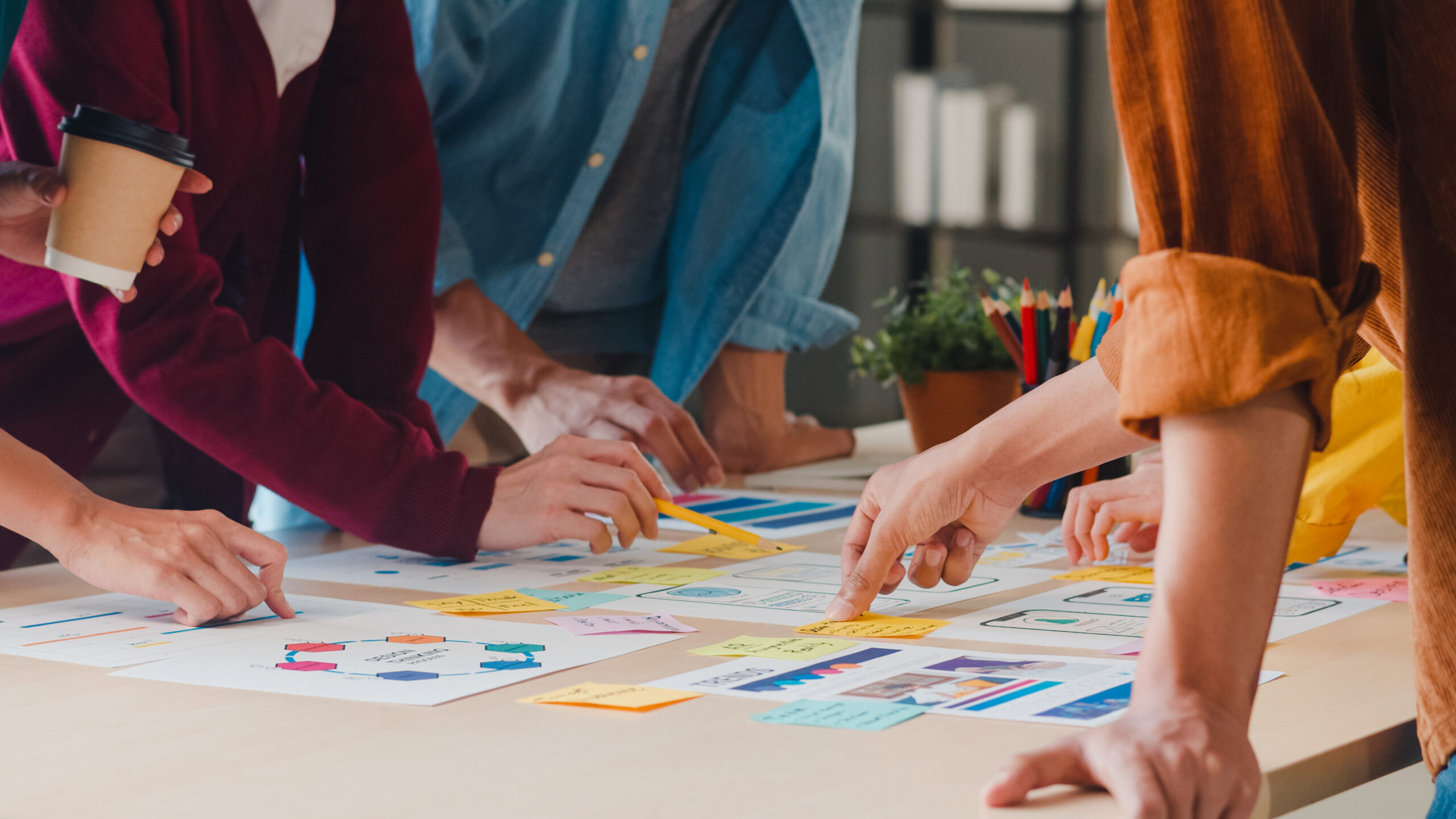 mains de personnes autour d'une table avec des post-it