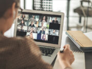 une personne travaille en visioconférence avec d'autres personnes sur son écran d'ordinateur