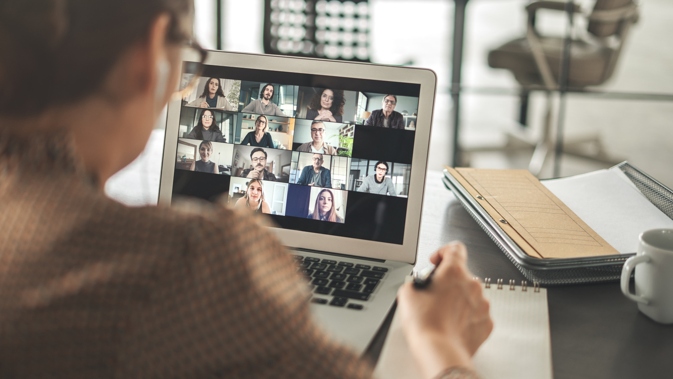 une personne travaille en visioconférence avec d'autres personnes sur son écran d'ordinateur