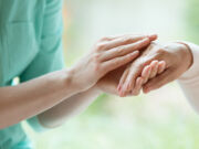 Une personne tient la main d'un malade