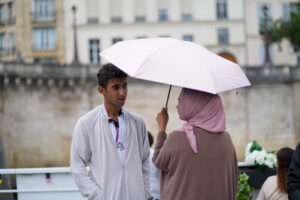 Une femme tenant un parapluie et un homme face à face en ville