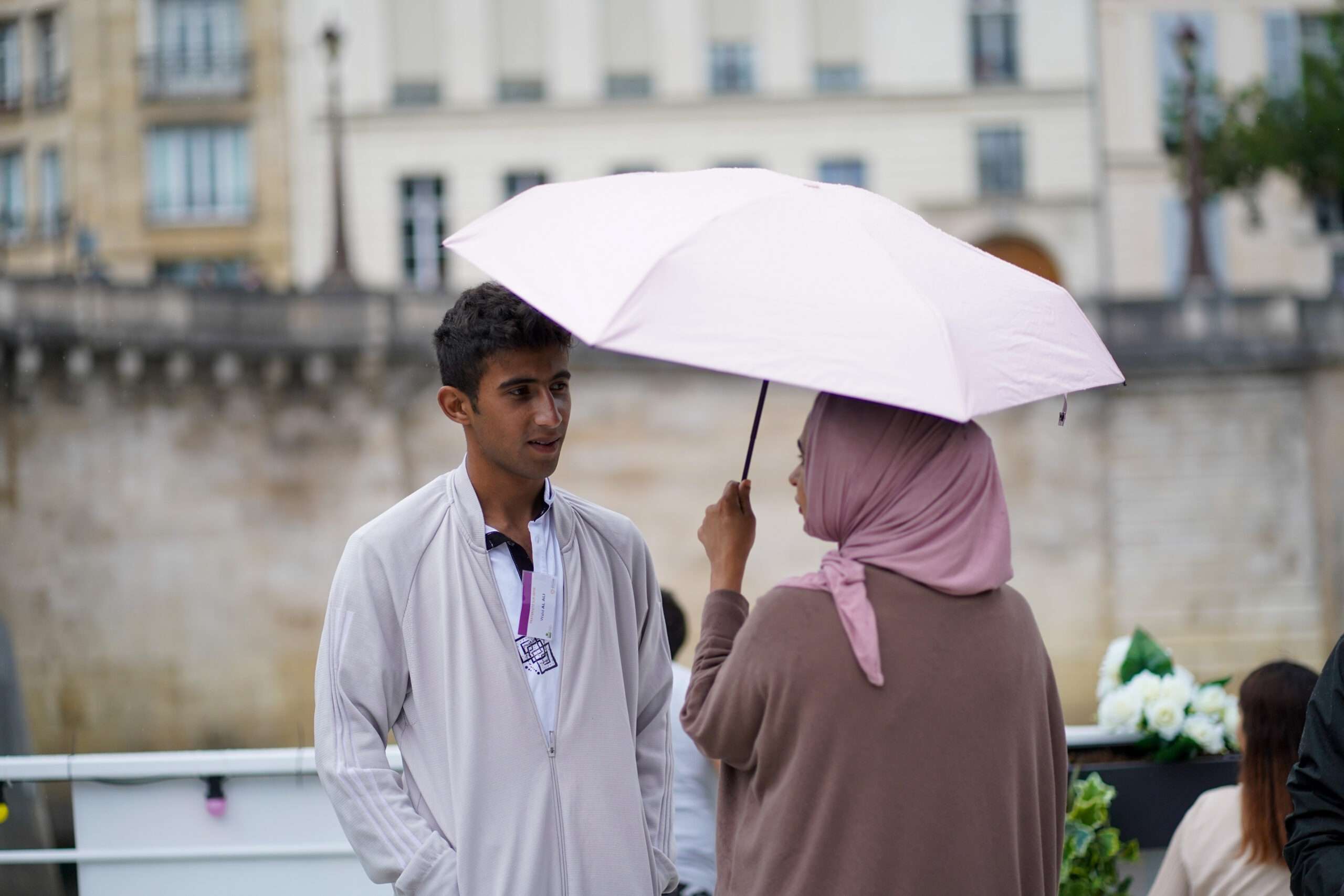 Une femme tenant un parapluie et un homme face à face en ville