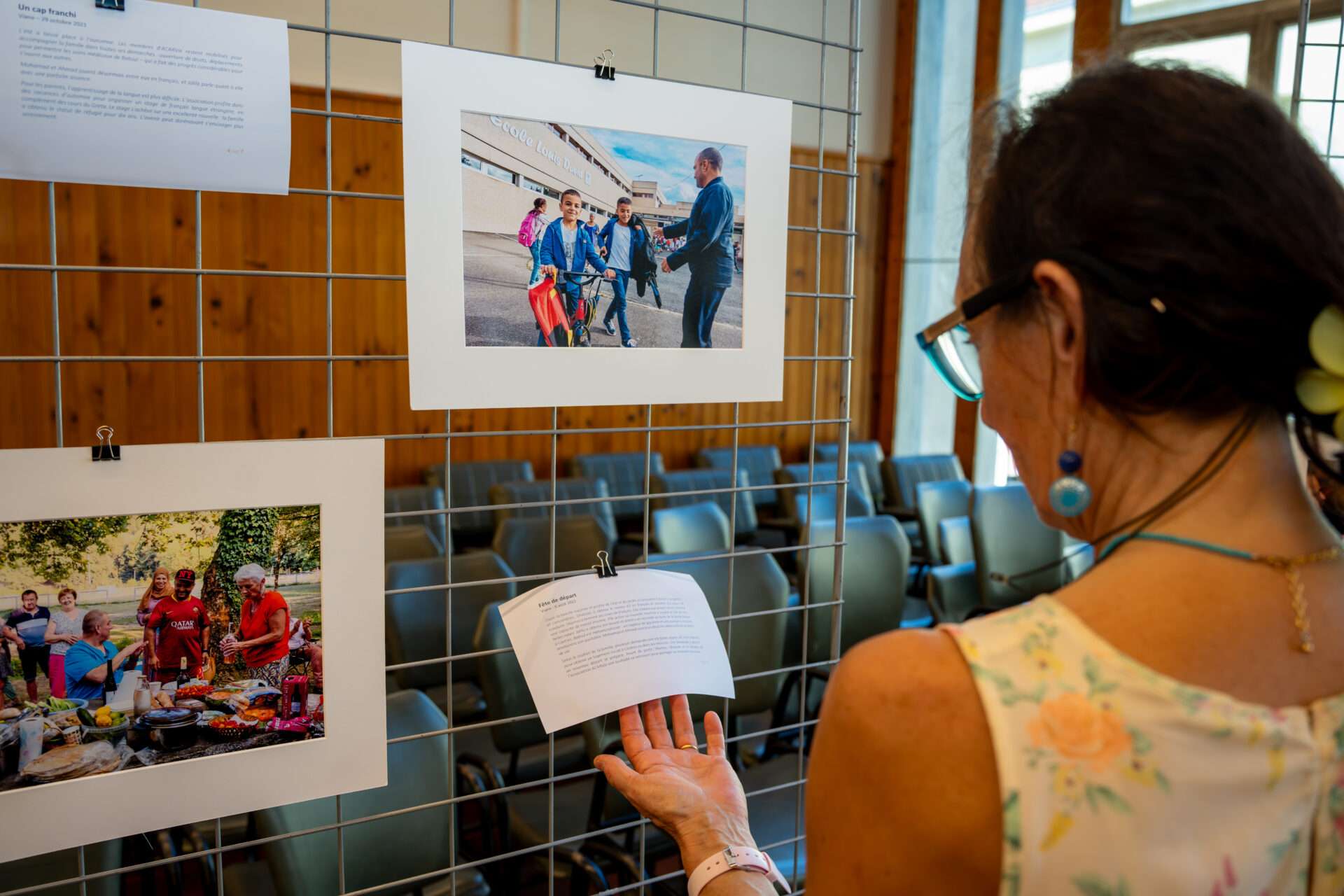 Une femme regarde une exposition photos.