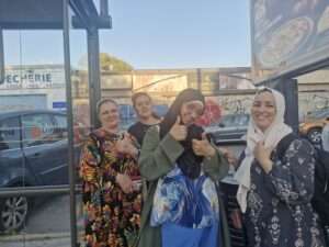 Des femmes sourient près d'un arrêt de bus