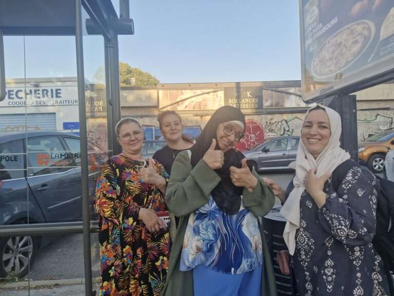 Des femmes sourient près d'un arrêt de bus