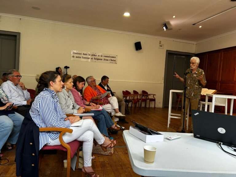 Des personnes assises dans une salle écoutent un conférencier